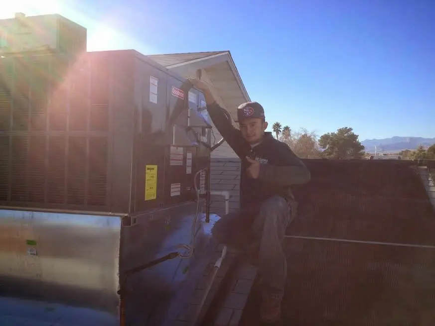 HVAC technician performing AC Tune-Up on a rooftop unit in Ramapo